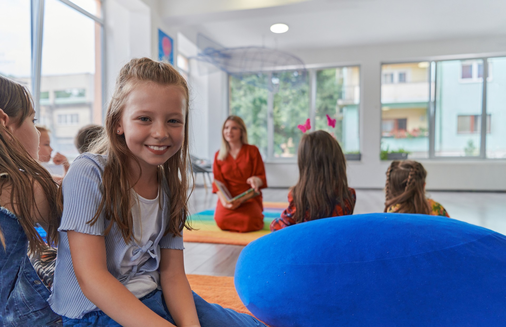 Reading time in an elementary school or kindergarten, a teacher reading a book to children in an elementary school or kindergarten. The concept of pre-school education. Selective focus